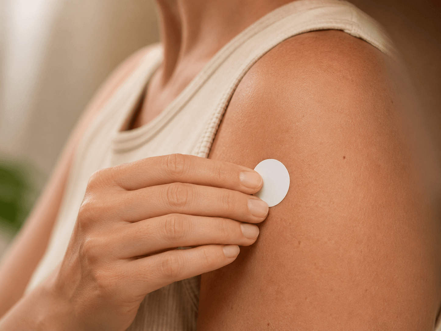 Small non-transdermal phototherapy patch being placed on an upper arm